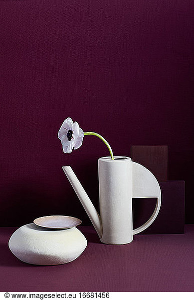 Moderne Vase  Blume auf burgunderrotem Filzhintergrund