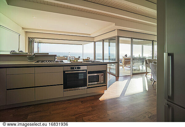 Moderne Wohnvitrinenküche mit sonnigem Meerblick