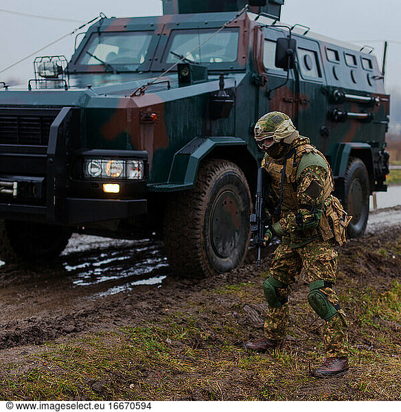 moderner Soldat bewegt sich verdeckt in gepanzertem Fahrzeug