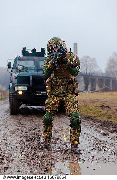 Moderner ukrainischer Soldat auf Patrouille mit einem gepanzerten Fahrzeug