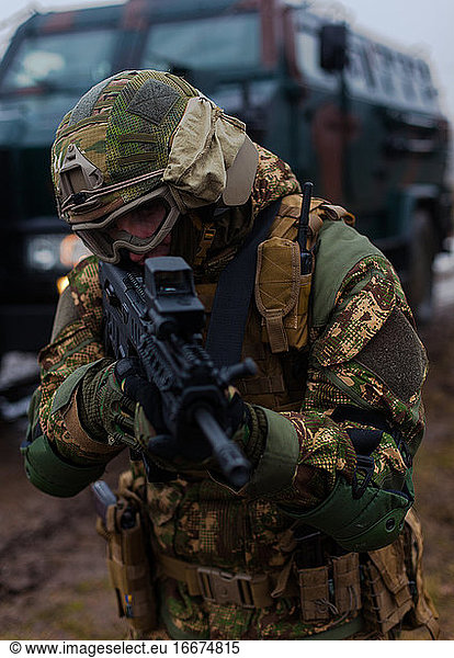 Moderner ukrainischer Soldat bewegt verdeckt gepanzerten Wagen