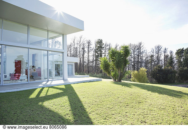 Modernes Haus wirft Schatten auf gepflegtem Rasen