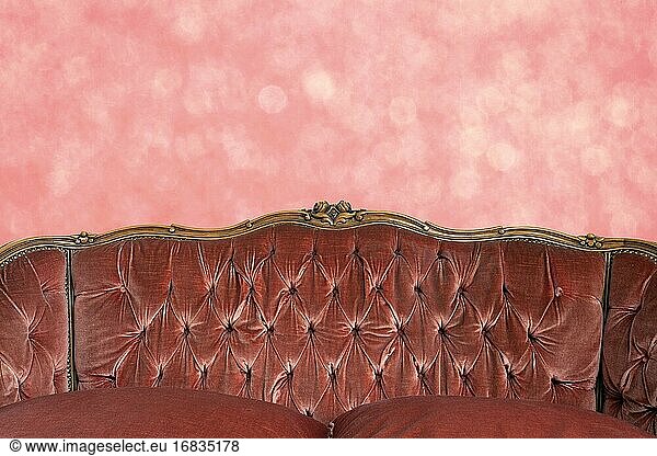 Modernes klassisches rosa Sofa mit rosa Bokeh-Wandmuster  luxuriöse Retro-Innenarchitektur  Kopierraum oder Raum für Text Hintergrund Nahaufnahme.