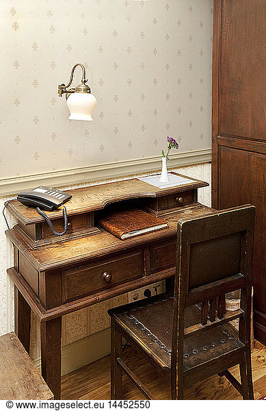 Modernes Telefon auf einem altmodischen Schreibtisch