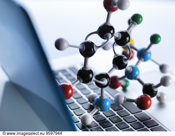 Molecular model sitting on top of lap top computer keyboard to illustrate science education and computer aided research