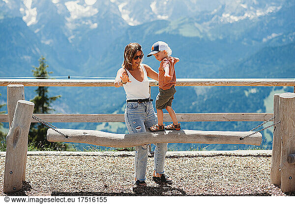 Mom and child playing in mountains playground in summer