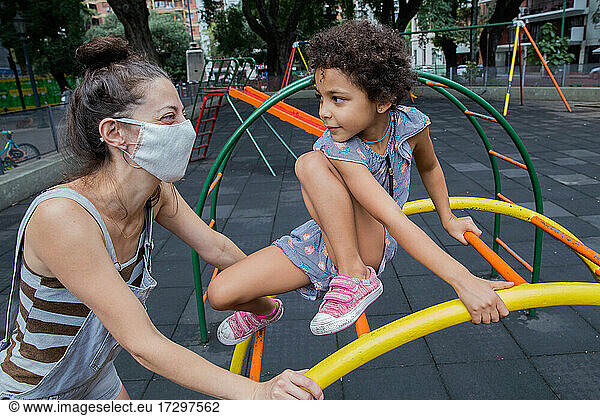 Mom and daughter enjoying at playground outside in a new normal life.