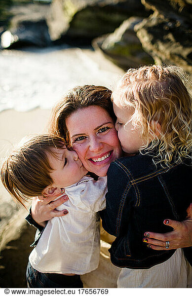 Mom Getting Kisses From Children on Beach in San Diego