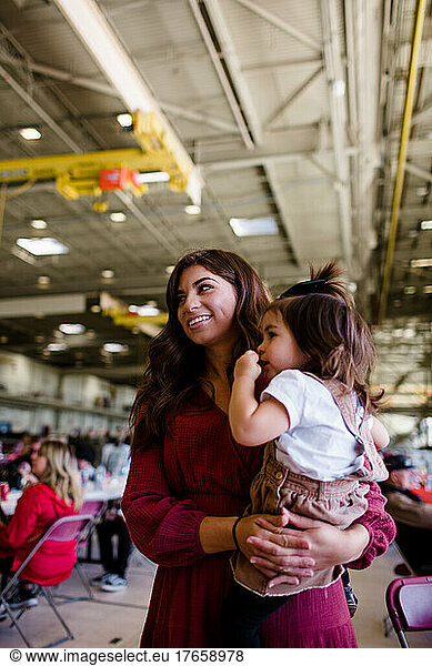 Mom Holding Daughter for Military Homecoming in San Diego
