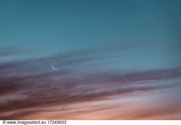Mondsichel leuchtet gegen den Himmel in der Abenddämmerung