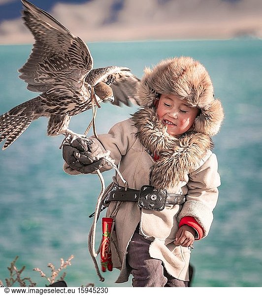 Mongolischer Falkenjäger  kleiner Junge mit dressiertem Falken  Provinz Bajan-Ölgii  Mongolei  Asien