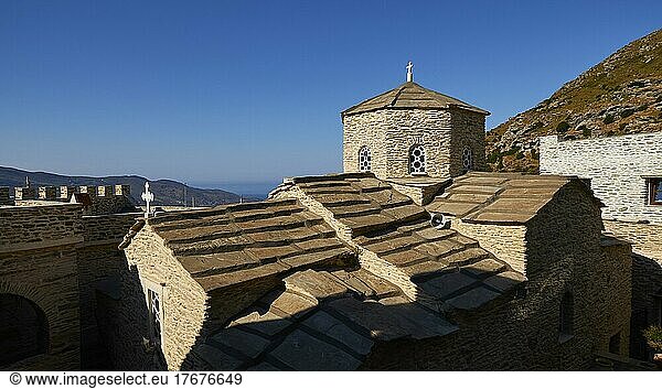 Moni Panachrantou  hexagonal stone church tower  church roof  tiled roof  fortress-like  rock monastery  blue cloudless sky  Andros island  Cyclades  Greece  Europe