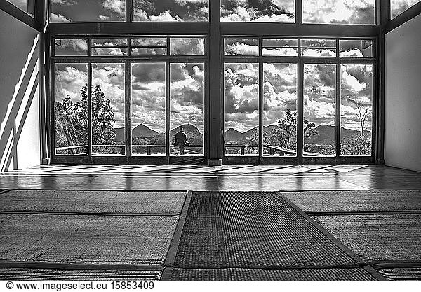 Monk meditating in a house among the mountains