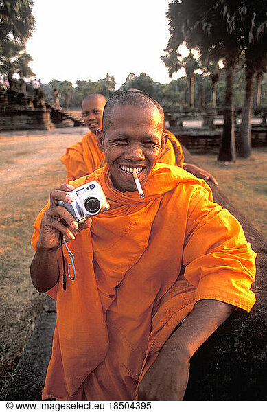 Monks with Camera and Cigarette at World's Largest Temple Angkor Wat Siem Reap Cambodia