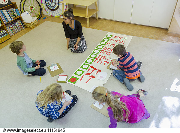 Montessori teacher and students working in classroom