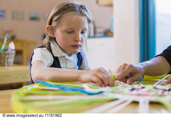 Montessori teacher helping student in classroom
