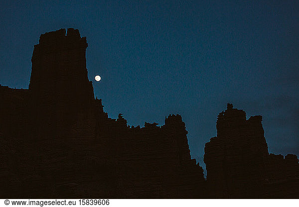 moonrise over the fisher towers at night near moab utah