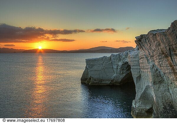 Morgenlicht  Sonnenaufgang  Sonne als Stern  orangeroter Himmel  Tuffgestein  Tuff-Felsen im Schatten  Sarakiniko Beach  Insel Milos  Kykladen  Griechenland  Europa