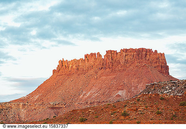 morning light turns red rock sandstone butte golden in canyonlands