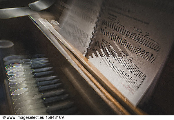 Morning sun sparkles on piano keys with sheet music creative blur