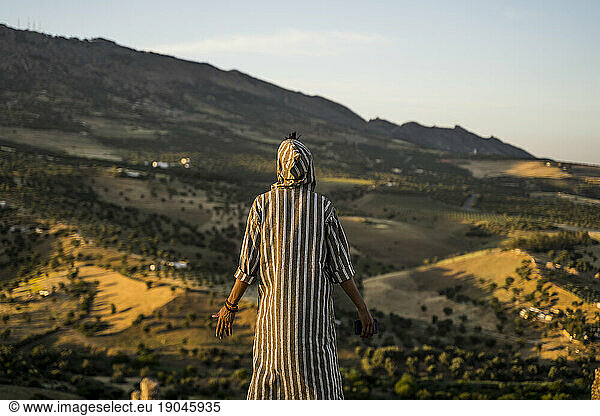 Moroccan man in typical Arabic attire with mobile phone in hand.