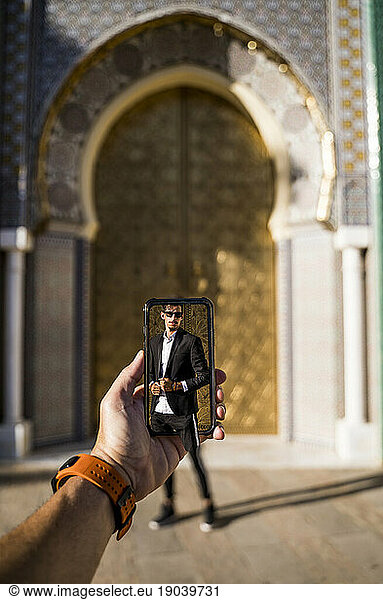 Moroccan man with sunglasses and suit. Get out of the phone