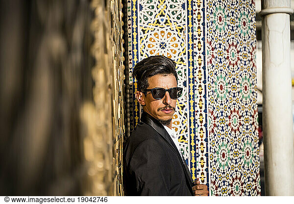 Moroccan man with sunglasses and suit next to Royal Palace in Fe