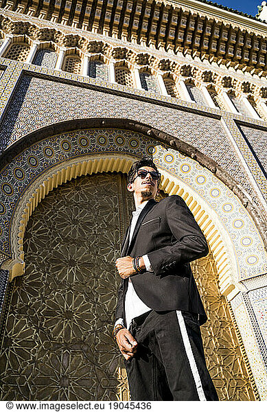 Moroccan man with sunglasses and suit next to Royal Palace in Fe
