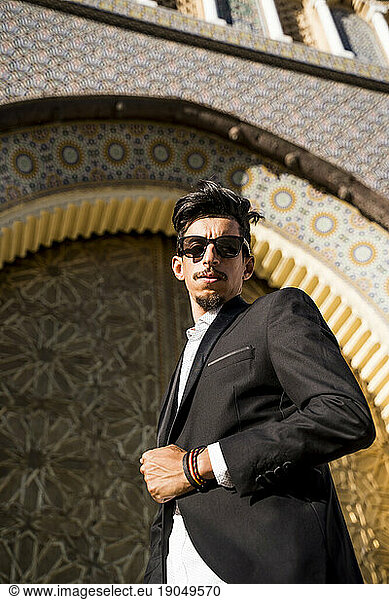 Moroccan man with sunglasses and suit next to Royal Palace in Fe
