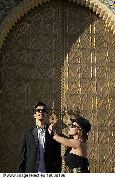 Moroccan man with sunglasses and suit together a beautiful woman