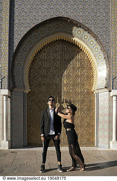 Moroccan man with sunglasses and suit together a beautiful woman