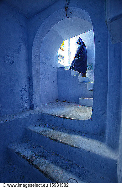 Morocco  Chefchaouen  Person in blue robe on whitewashed steps