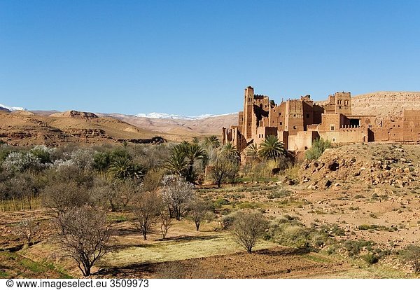 Morocco - The beautiful Tamdaght kasbah = fortress is located just a few km north of the world-famous kasbahs of Aït Benhaddou In the background the snow-capped High Atlas mountains Southern Morocco