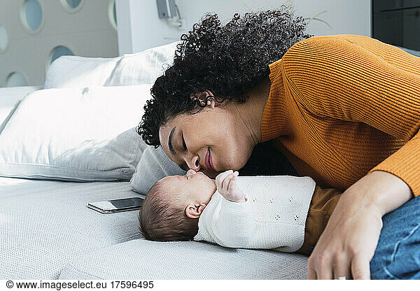 Mother and baby boy lying on sofa at home