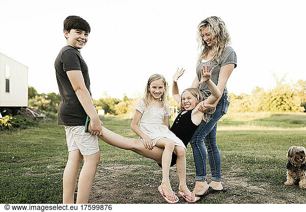 Mother and brother playing with girls at farm