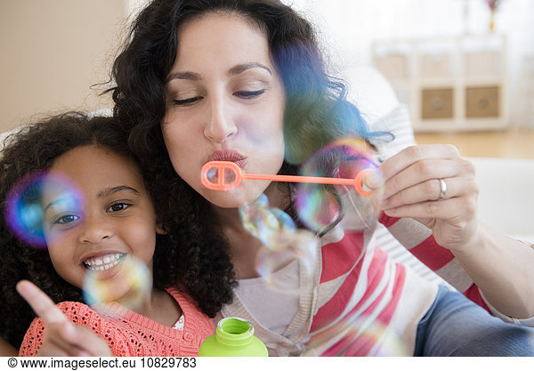 Mother and daughter blowing bubbles