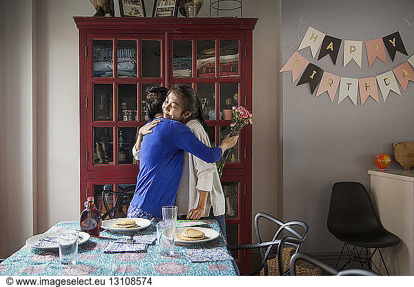 Mother and daughter embracing during birthday celebration