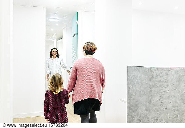 Mother and daughter entering medical practice