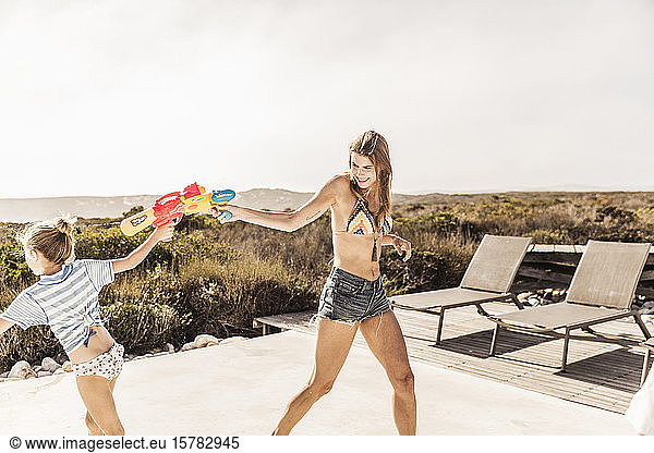 Mother and daughter having a water fight