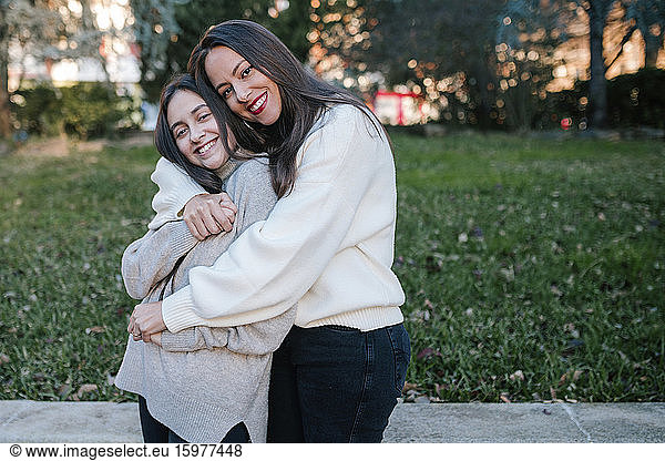 Mother and daughter hugging in a park