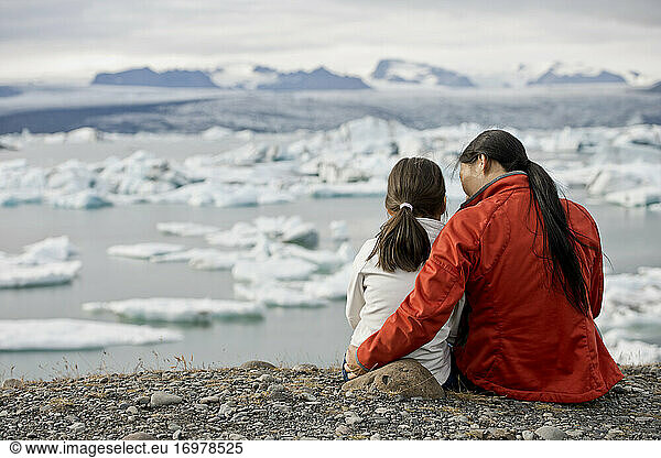 Mother and daughter looking at glacier lagoon in Iceland