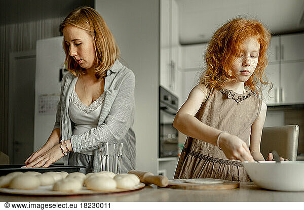 Mother and daughter making cheesecake at home