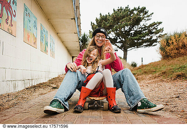 mother and daughter on a skateboard laughing having fun