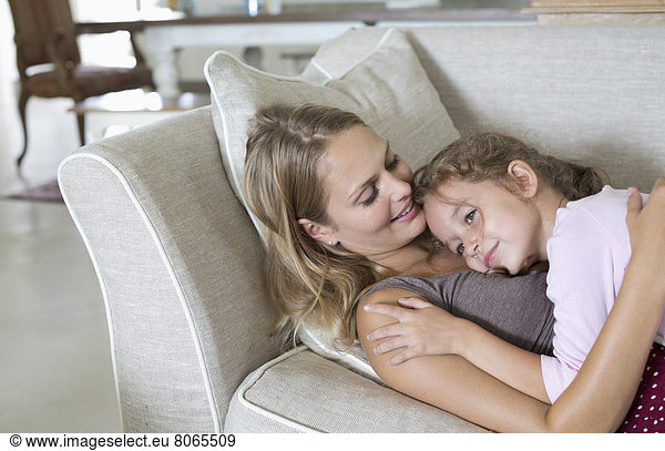 Mother and daughter relaxing on sofa