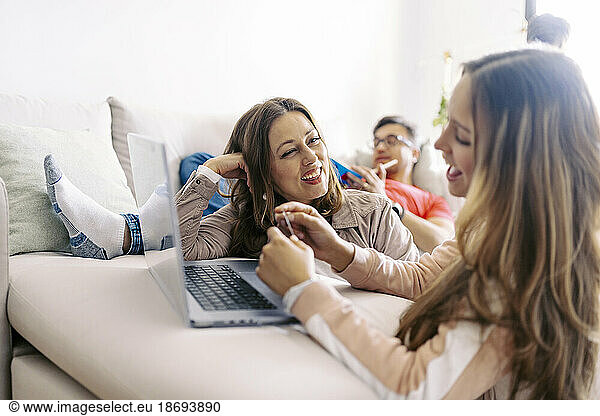 Mother and daughter shopping online through laptop at home