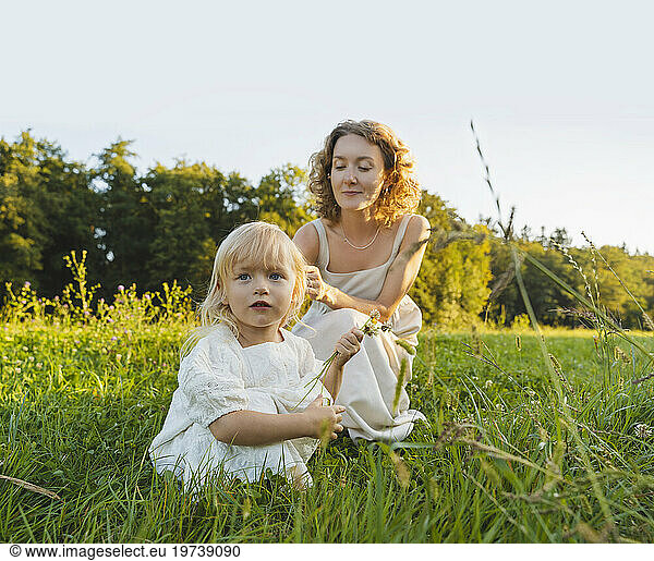Mother and daughter spending time together on grass