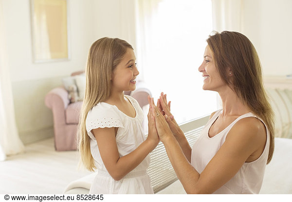 Mother and daughter touching hands