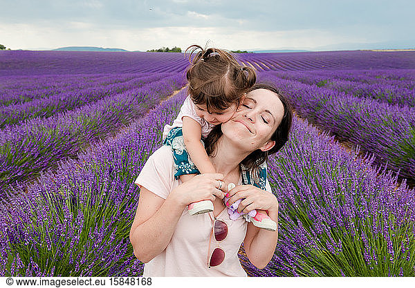 Mother and daughter walking among lavender fields in the summer