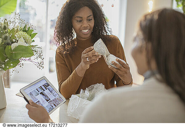 Mother and daughter with digital tablet and wedding shoes