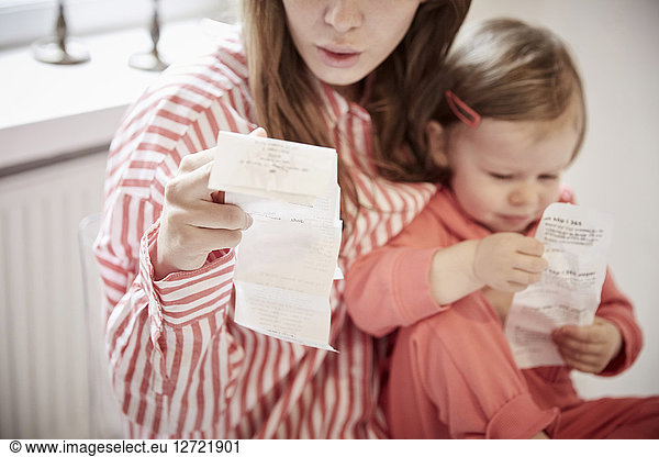 Mother and daughter with financial bills at home